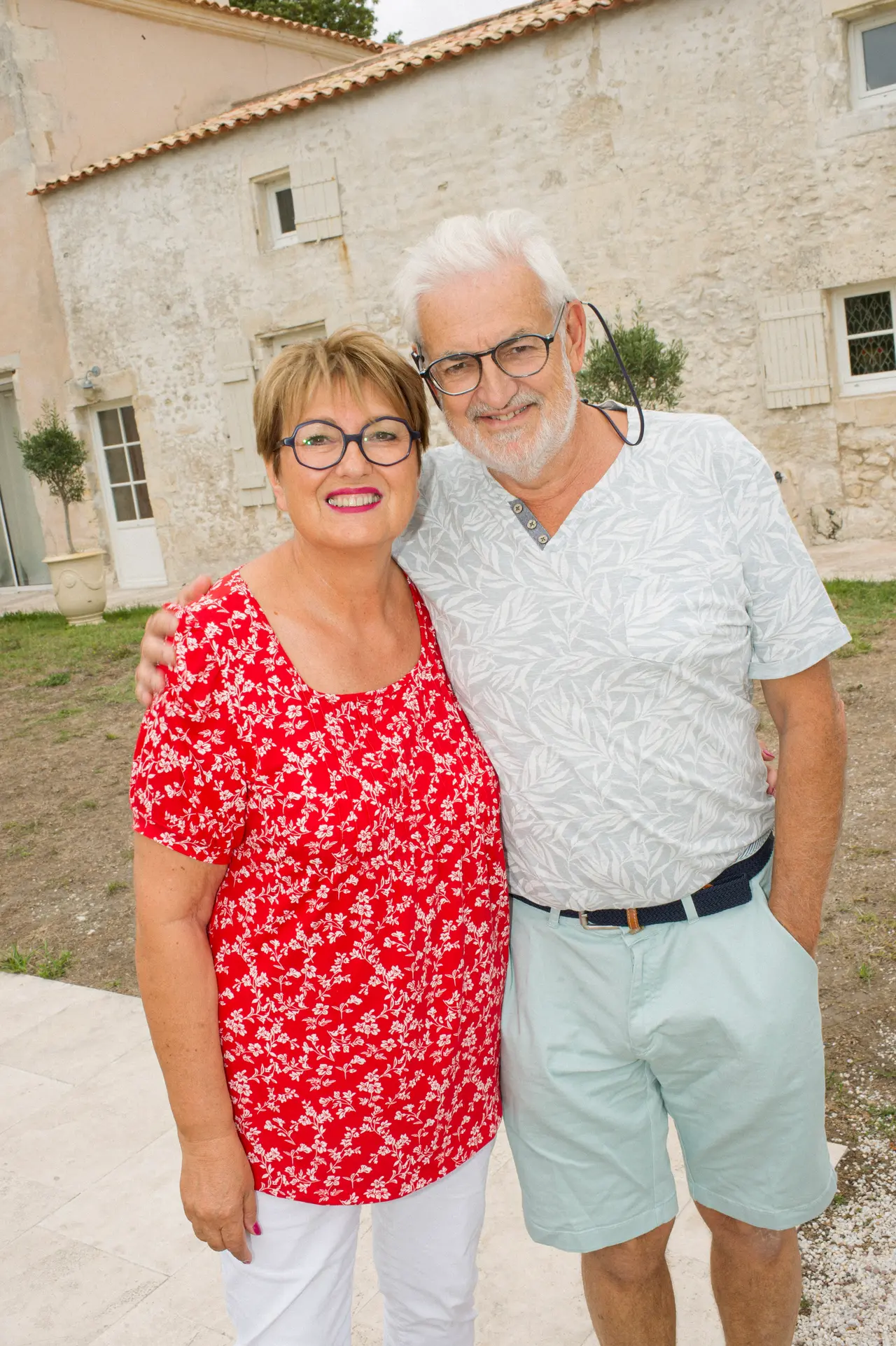un couple d'invités pose devant la maison en pierre