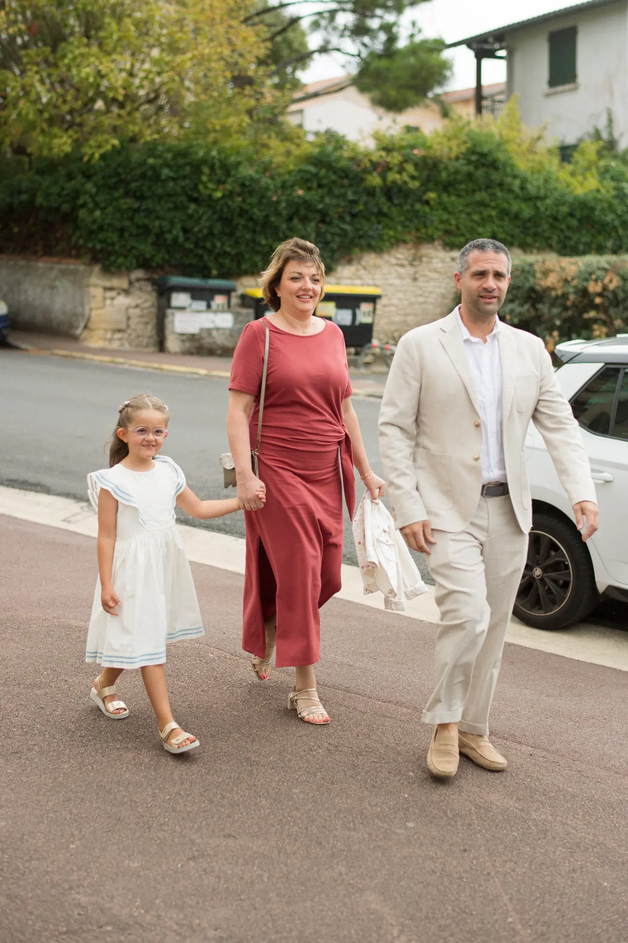 des invités et une petite fille traversent vers l'église
