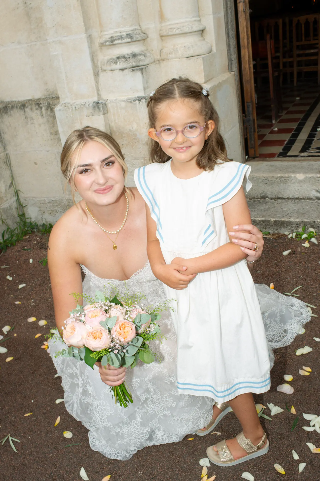 la mariée et une petite fille en blanc, bouquet partagé
