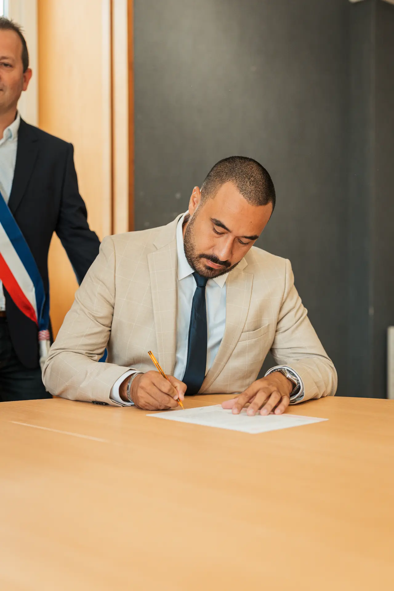 la signature devant l'écharpe tricolore