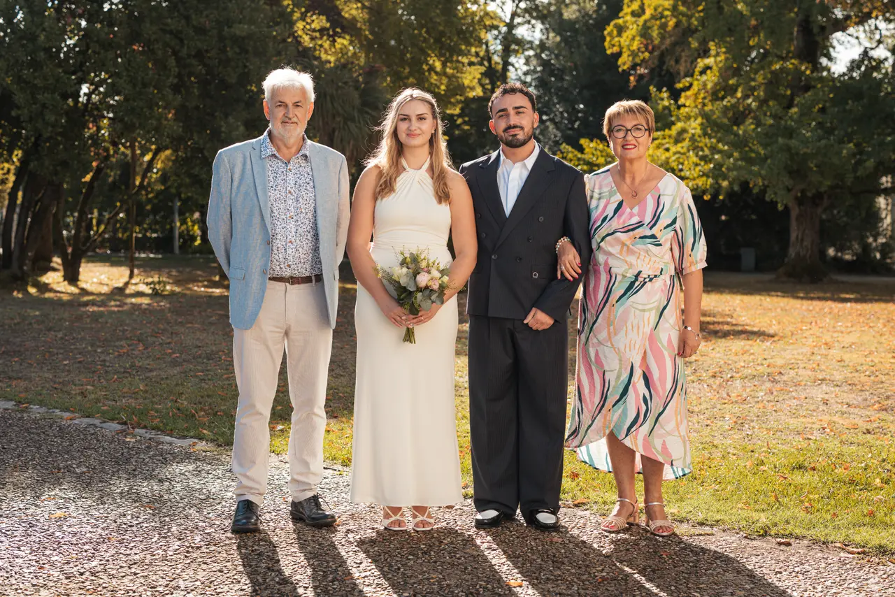 Les mariés, un invité en veste bleu clair et une invitée en robe colorée