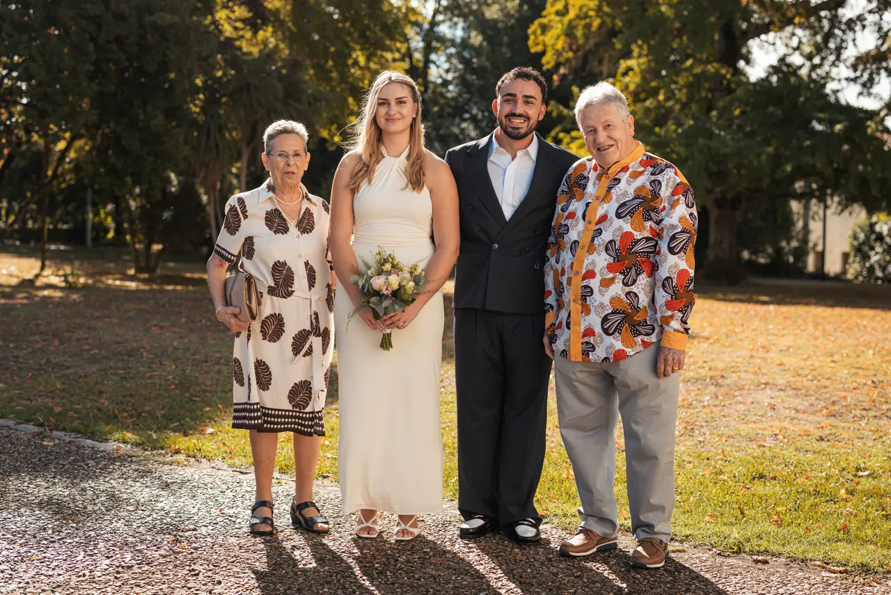 Les mariés, une invitée en robe à motifs et un invité en chemise fleurie
