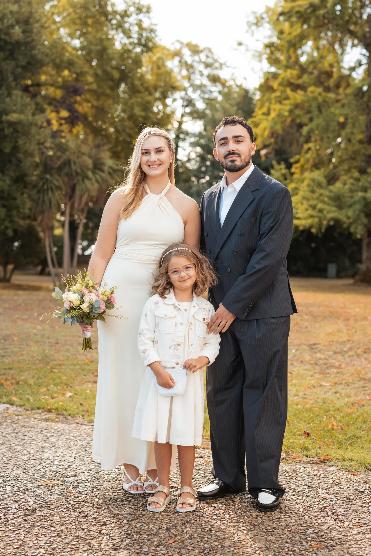 Les mariés et une petite invitée en robe blanche