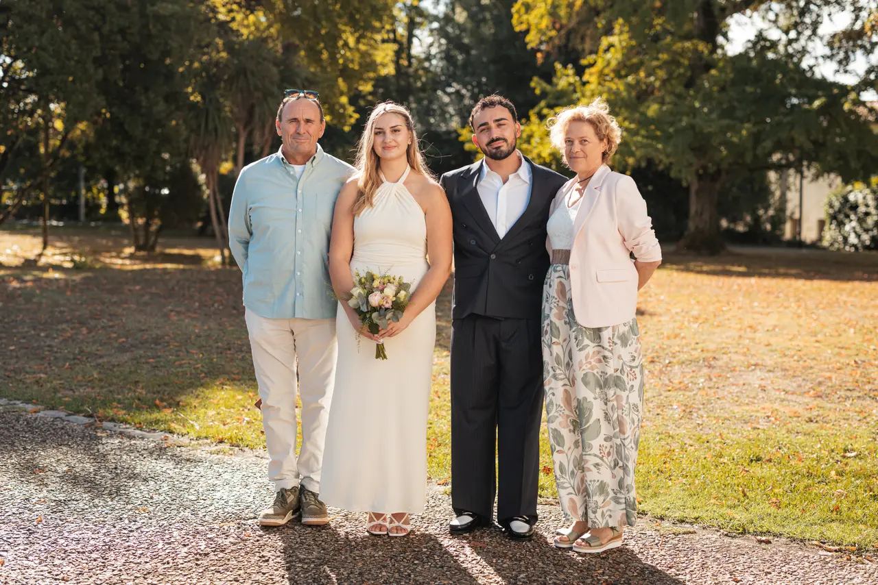 Les mariés, un invité en chemise bleue et une invitée en veste rose