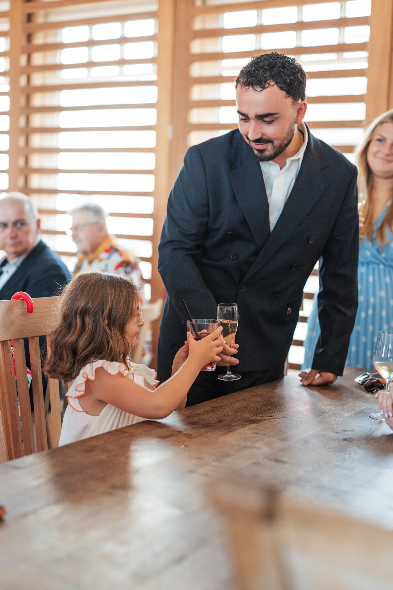 le marié sert une coupe à une petite invitée