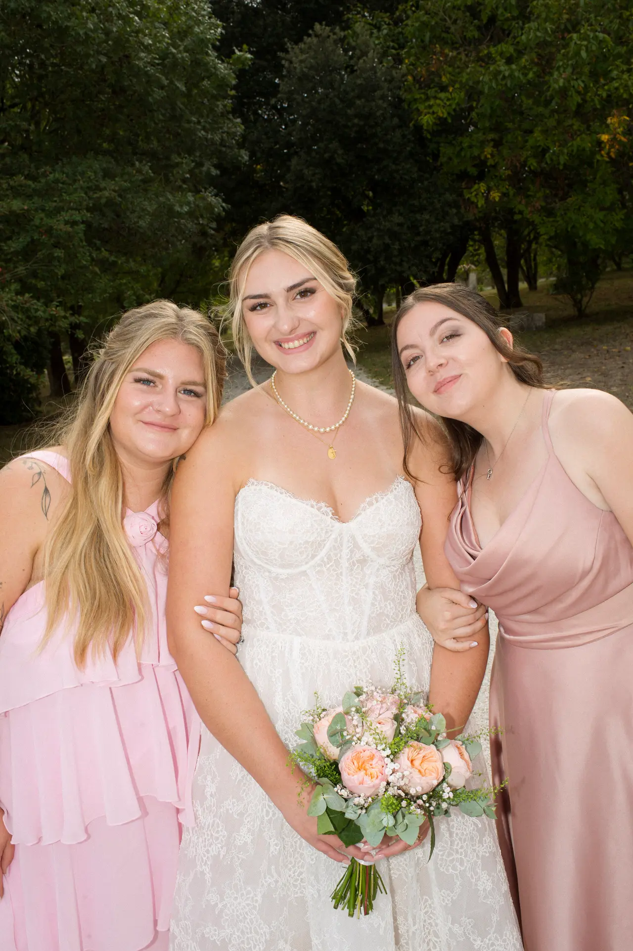 mariée serrée entre deux femmes en robes rose volantée et satin rose, allée