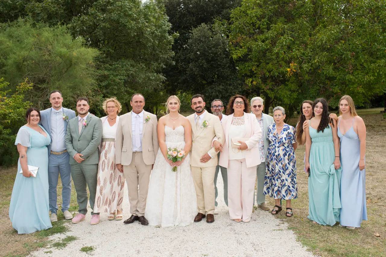quinze personnes autour des mariés, robes bleu ciel et turquoise, costumes clairs, allée