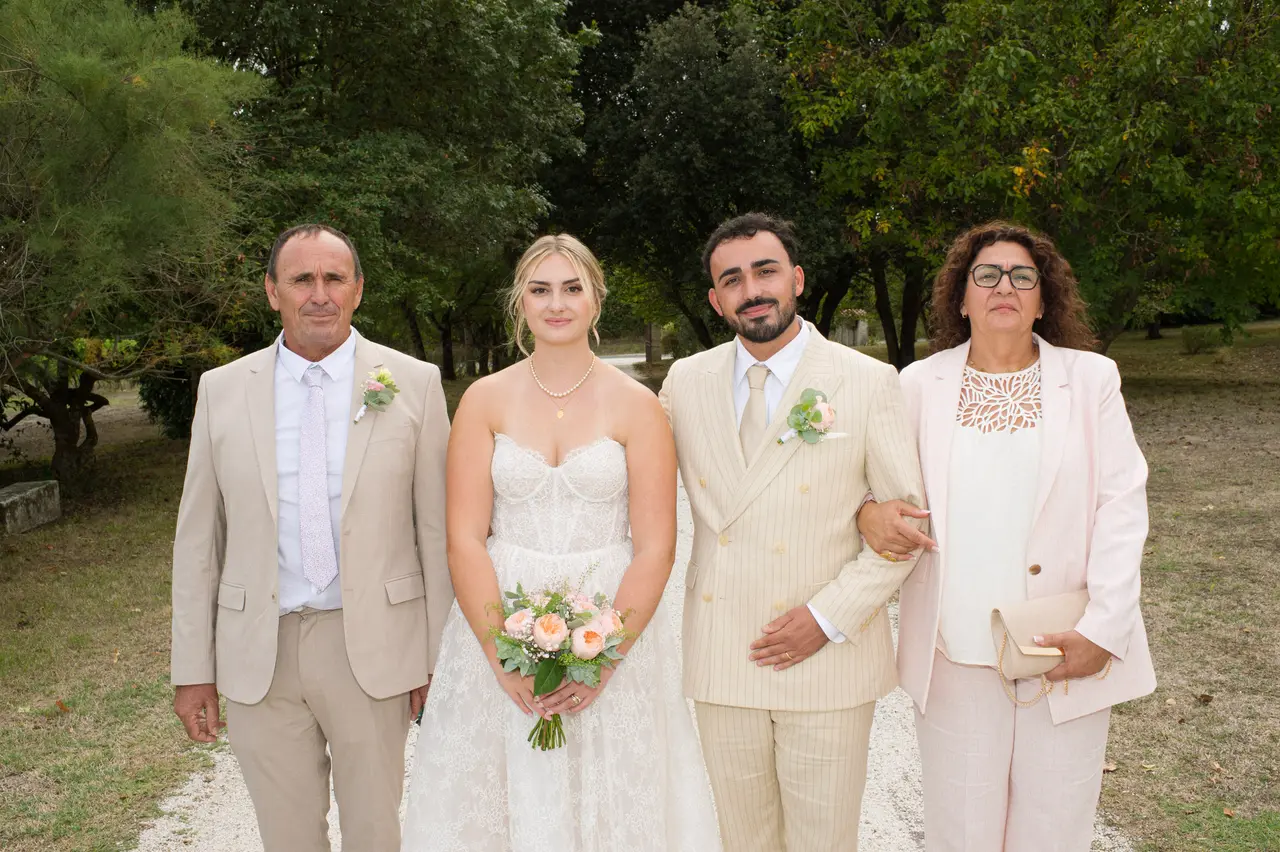 mariés entre un homme en costume beige et une femme en tailleur rose pâle