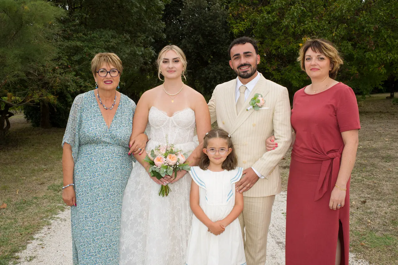 mariés, fillette en robe blanche, femme en robe bleue fleurie et femme en robe terracotta, allée du parc