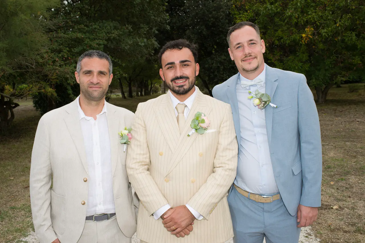 le marié entre un homme en costume lin beige et un homme en veste bleu ciel