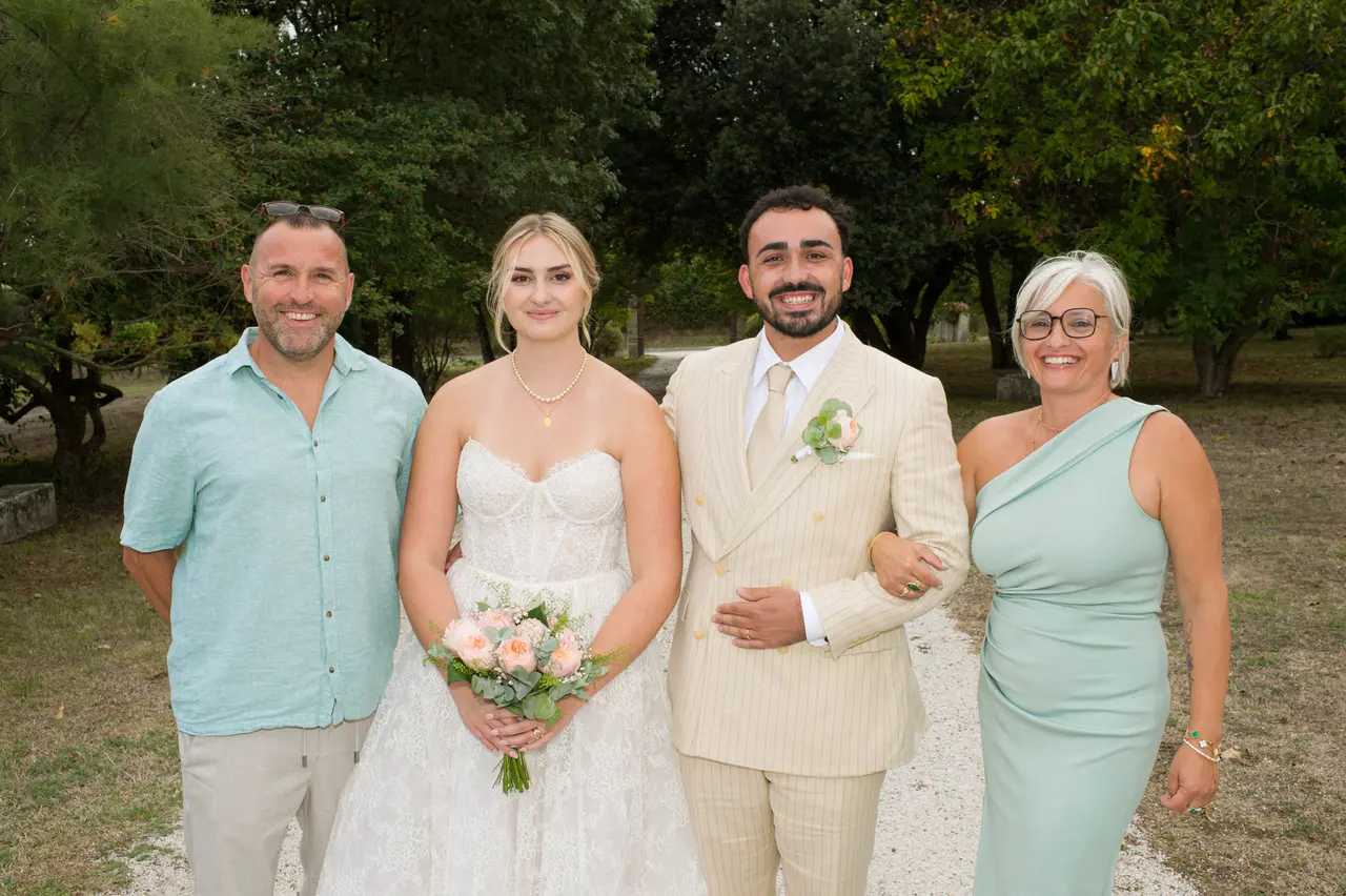 les mariés entre un homme en chemise turquoise et une femme en robe vert d'eau asymétrique