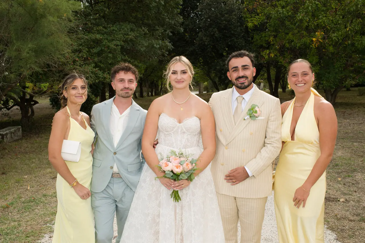 les mariés avec deux femmes en robes jaunes satinées et un homme en costume bleu-gris