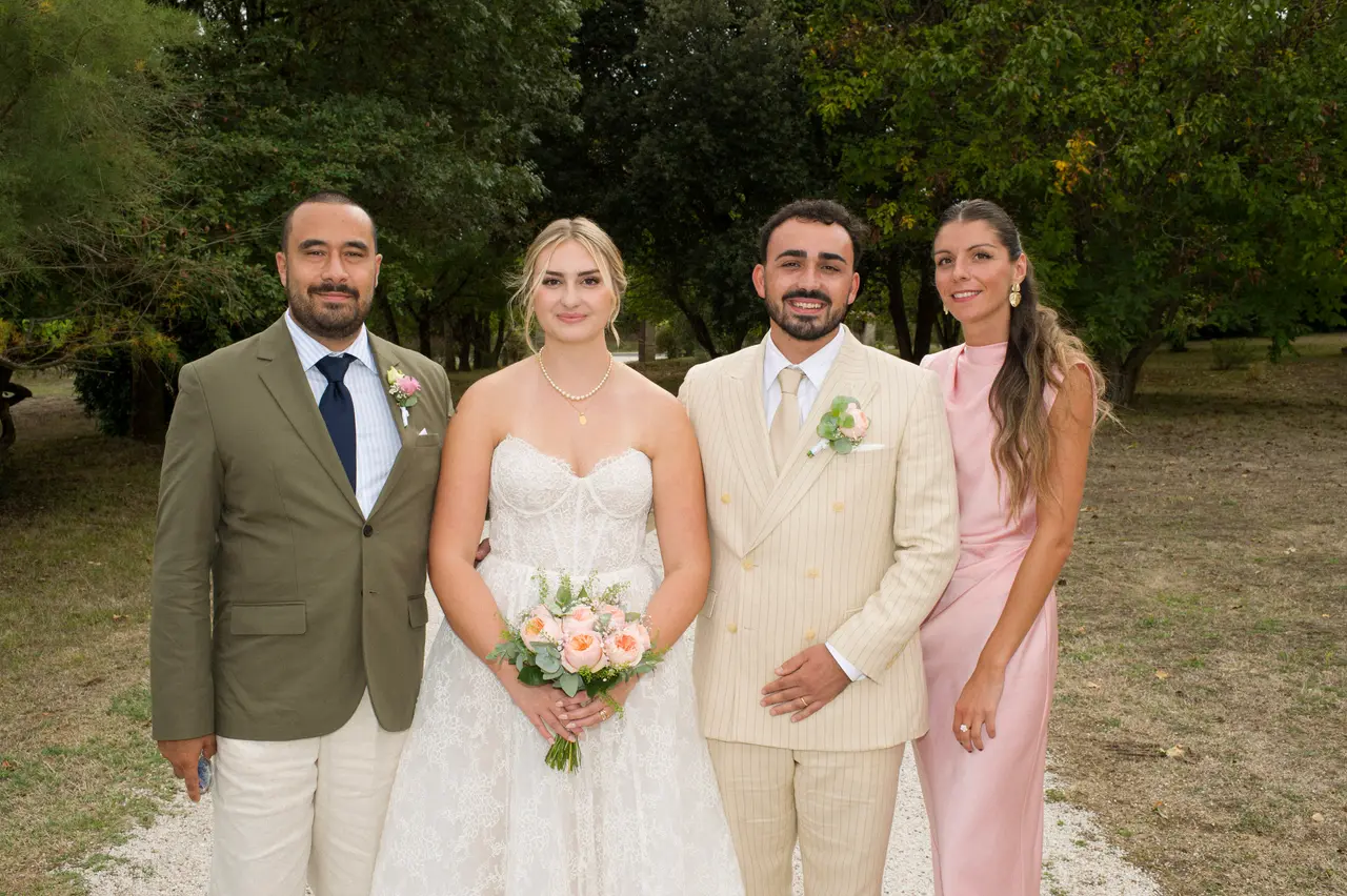 les mariés entre un homme en veste kaki et cravate marine et une femme en robe rose