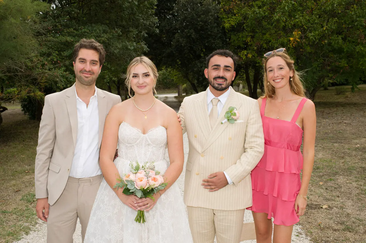 mariés entre homme en costume beige et femme en robe rose fuchsia à volants
