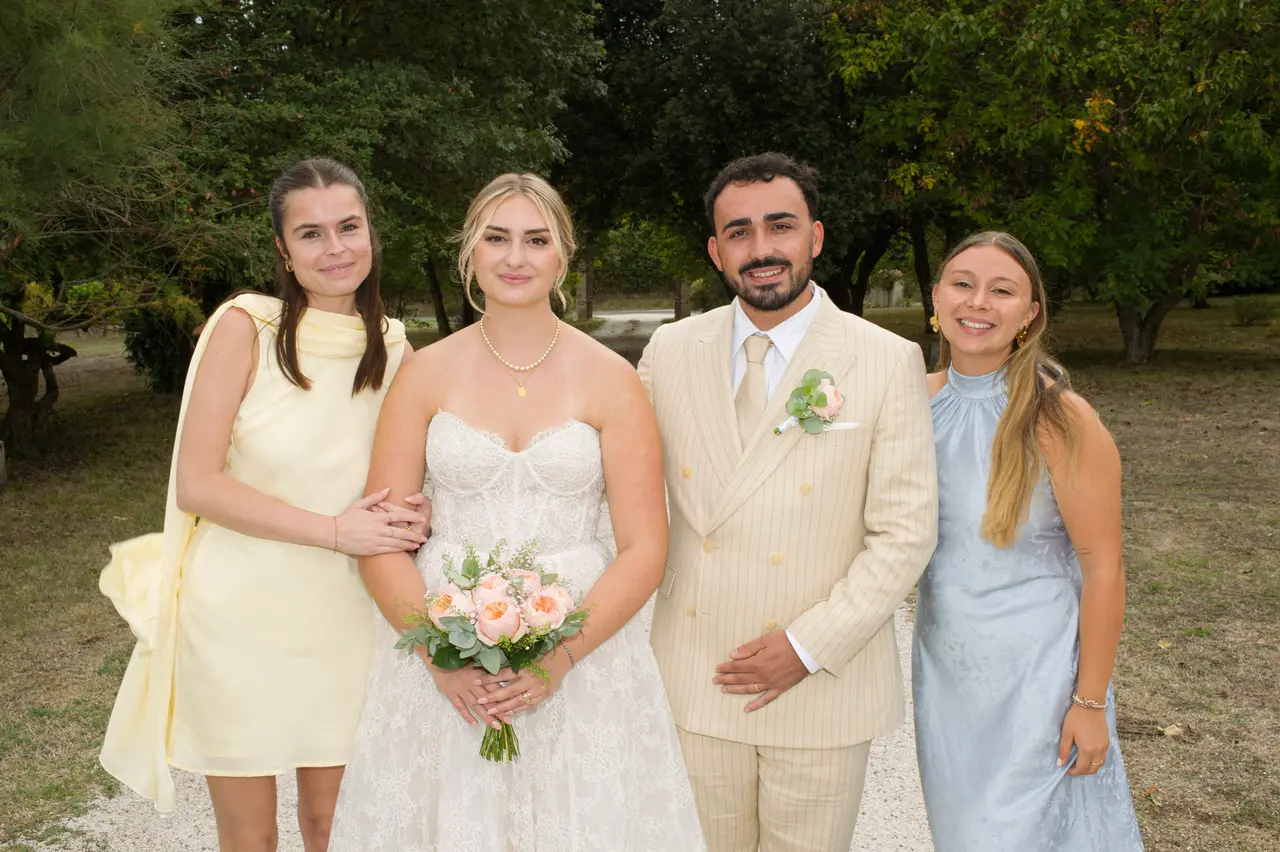 mariés entre femme en robe jaune pâle et femme en robe bleu ciel satinée