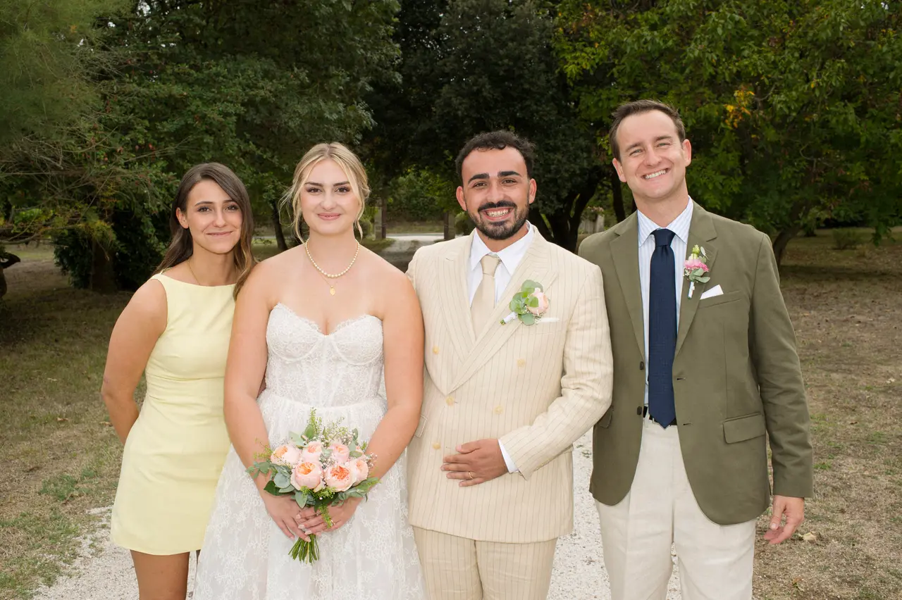les mariés entre une femme en robe courte jaune pâle et un homme en veste kaki