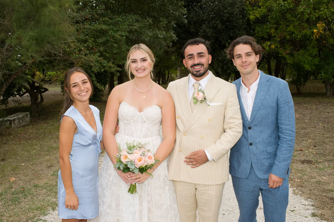 Les mariés entre une robe satin bleu ciel et un costume bleu, allée de gravier arborée