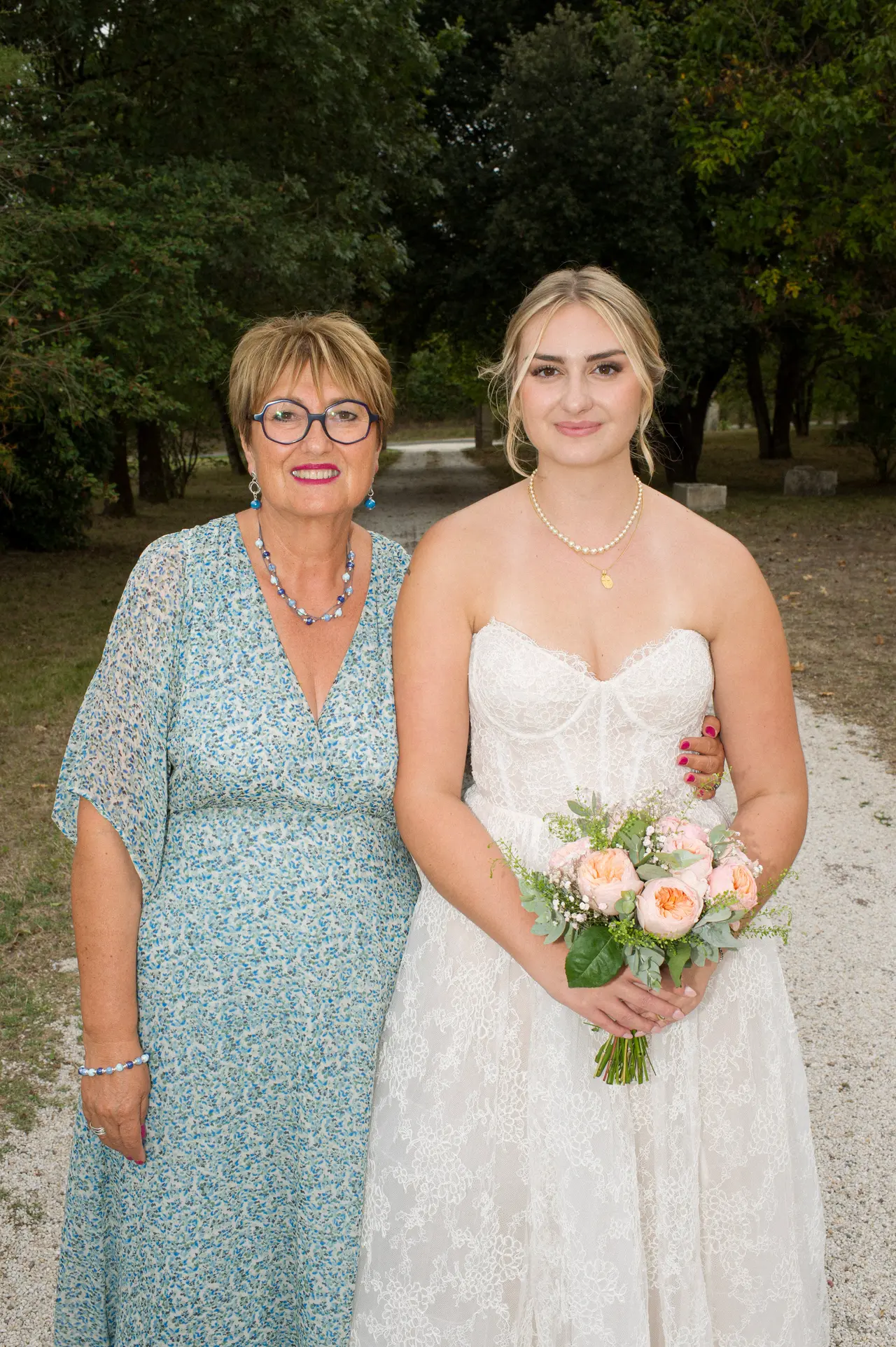une invitée et la mariée bras dessus bras dessous