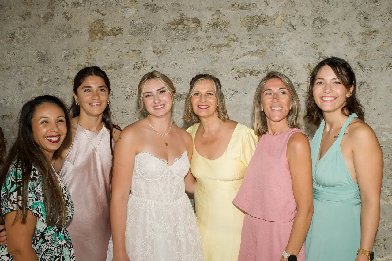 la mariée entourée de six amies contre le mur de pierre