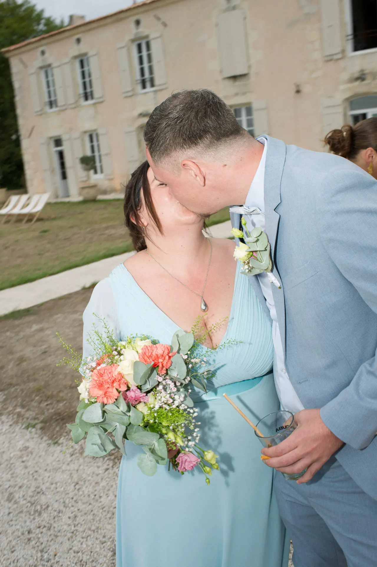 le couple gagnant s'embrasse, bouquet serré entre eux