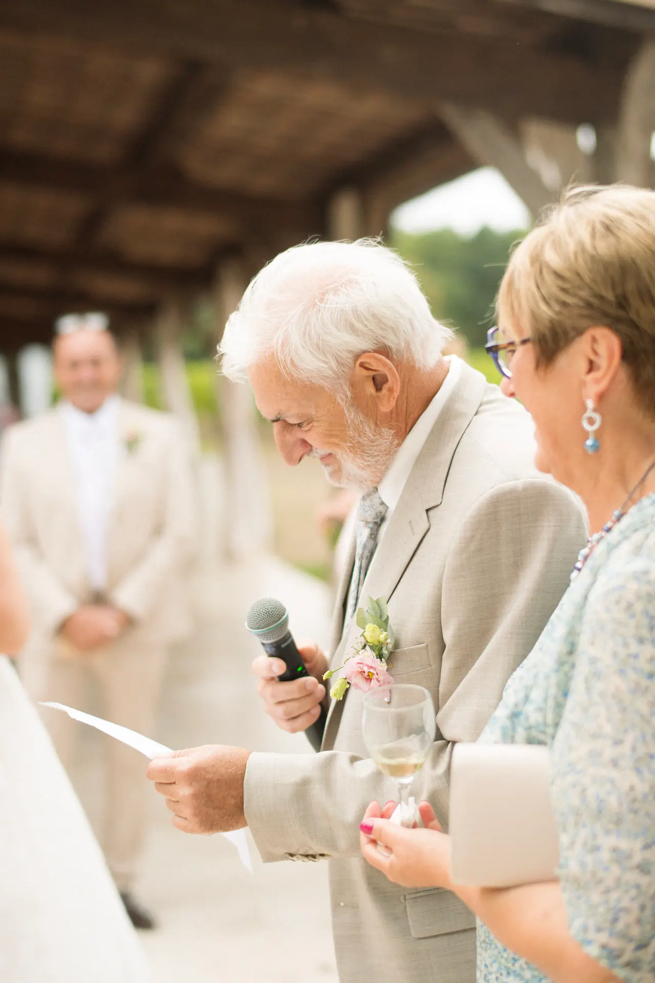 un invité lit un discours au micro, feuille en main