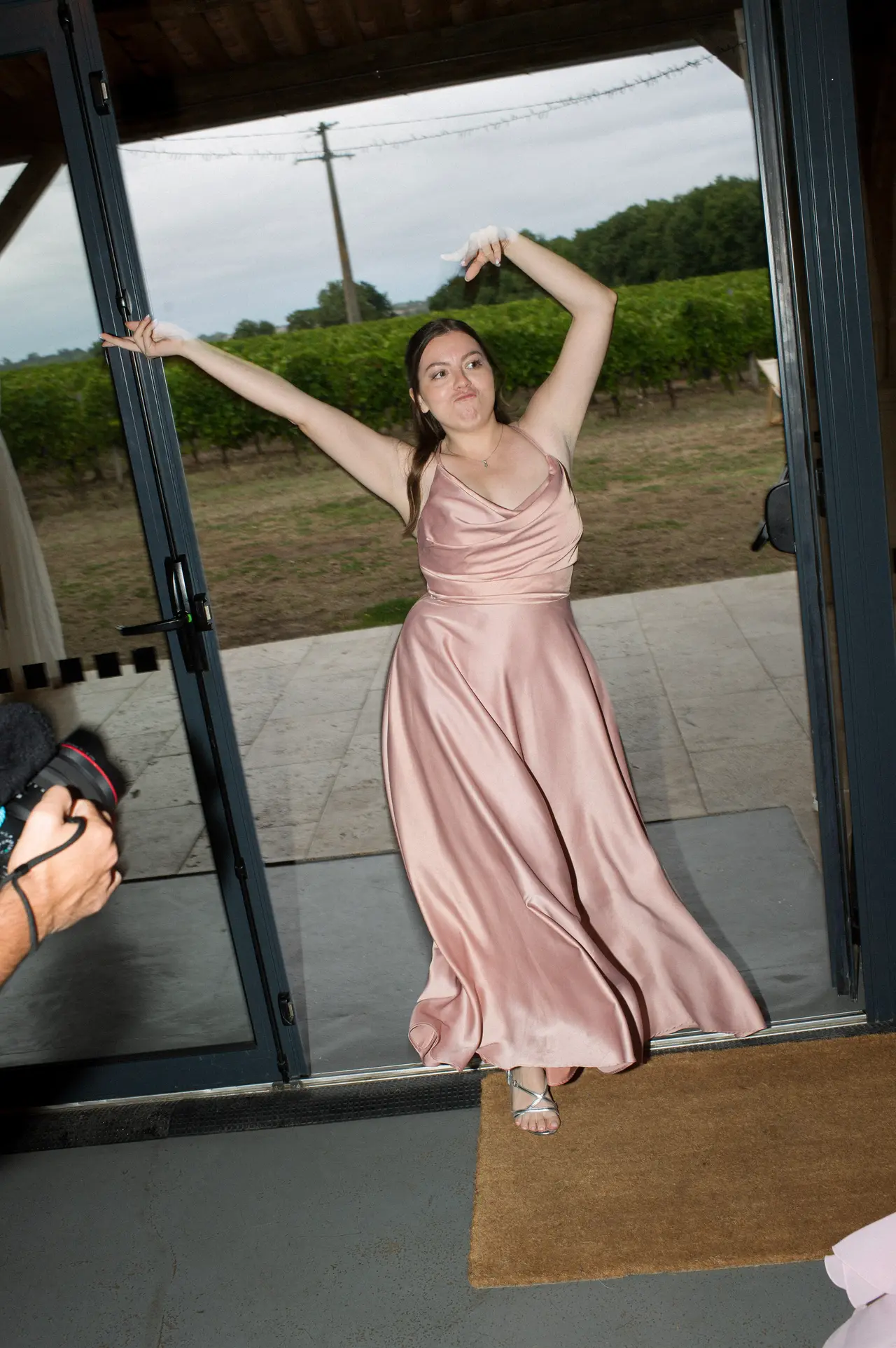 demoiselle en satin rose, bras levés, robe en mouvement