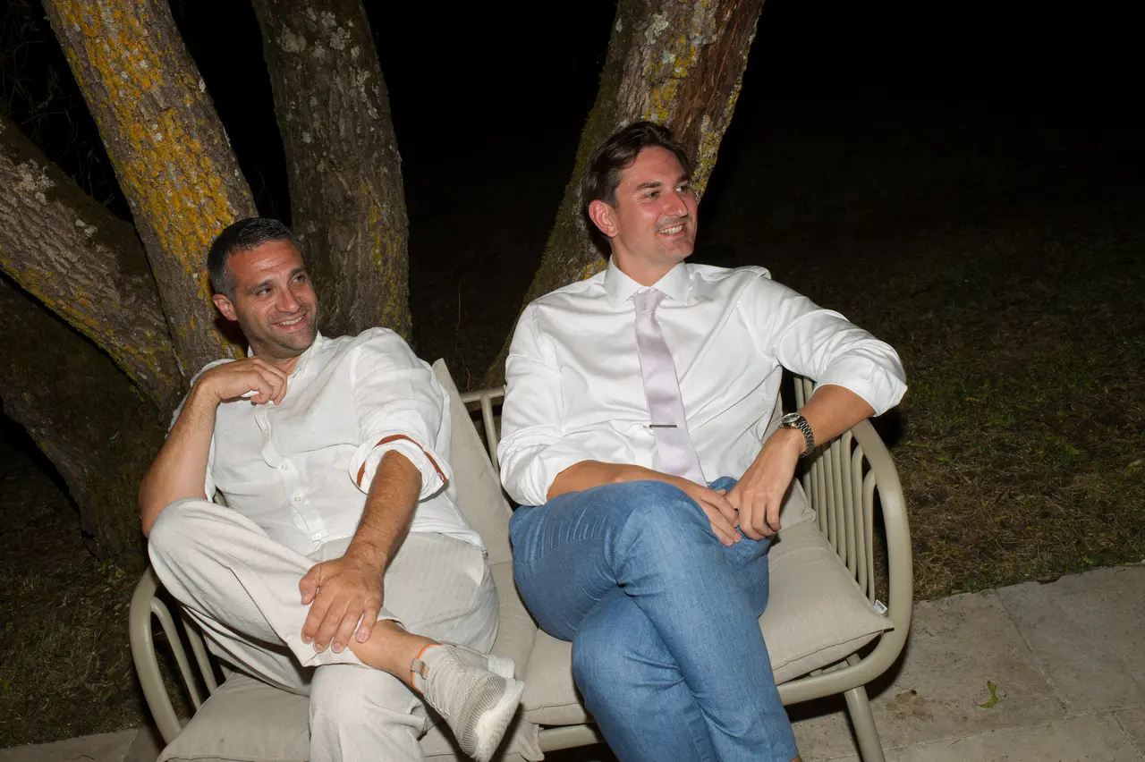deux invités avachis dans des fauteuils dehors sous les arbres