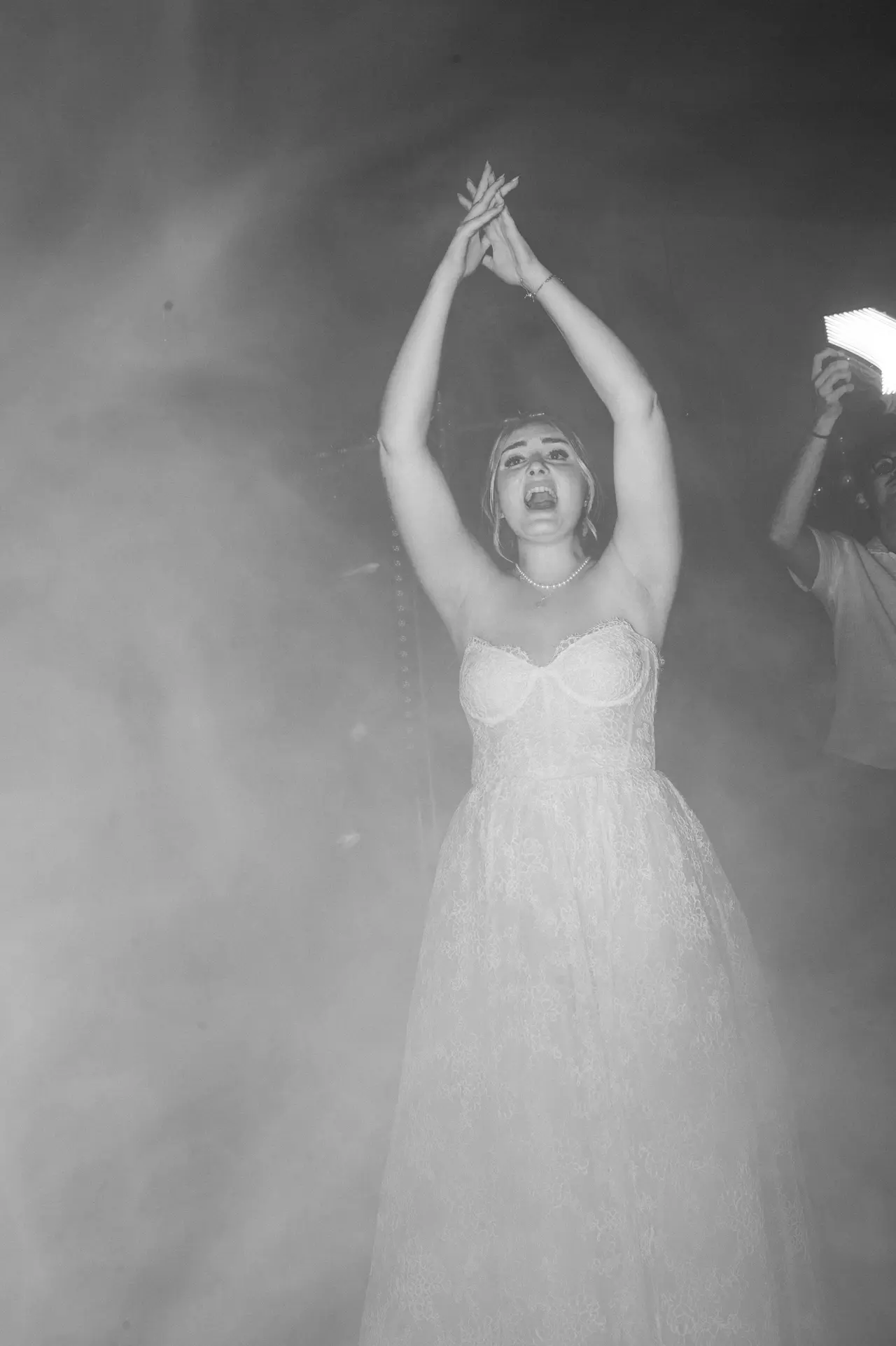 la mariée seule dans la fumée, bras levés, cri de joie, N&B