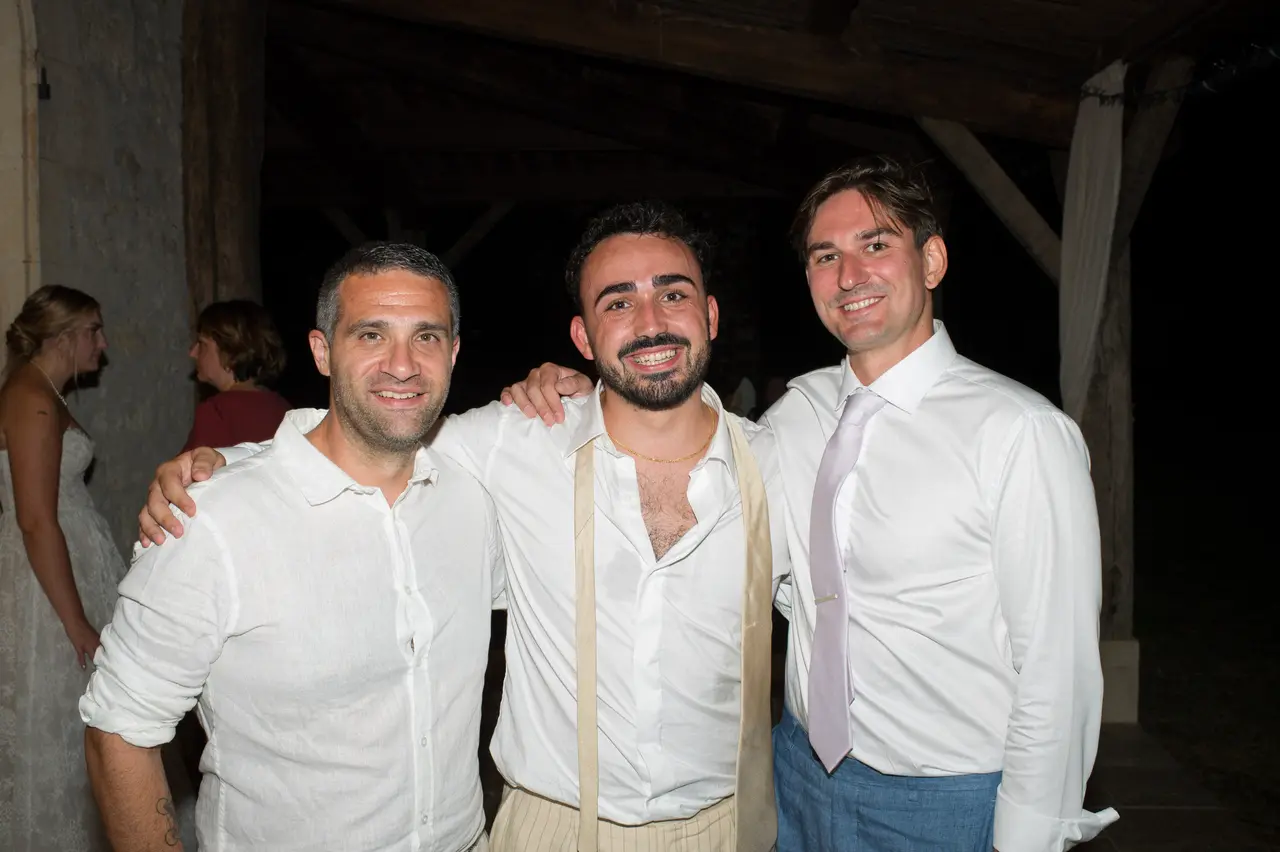 marié en chemise blanche et bretelles entre deux hommes en chemises blanches, nuit